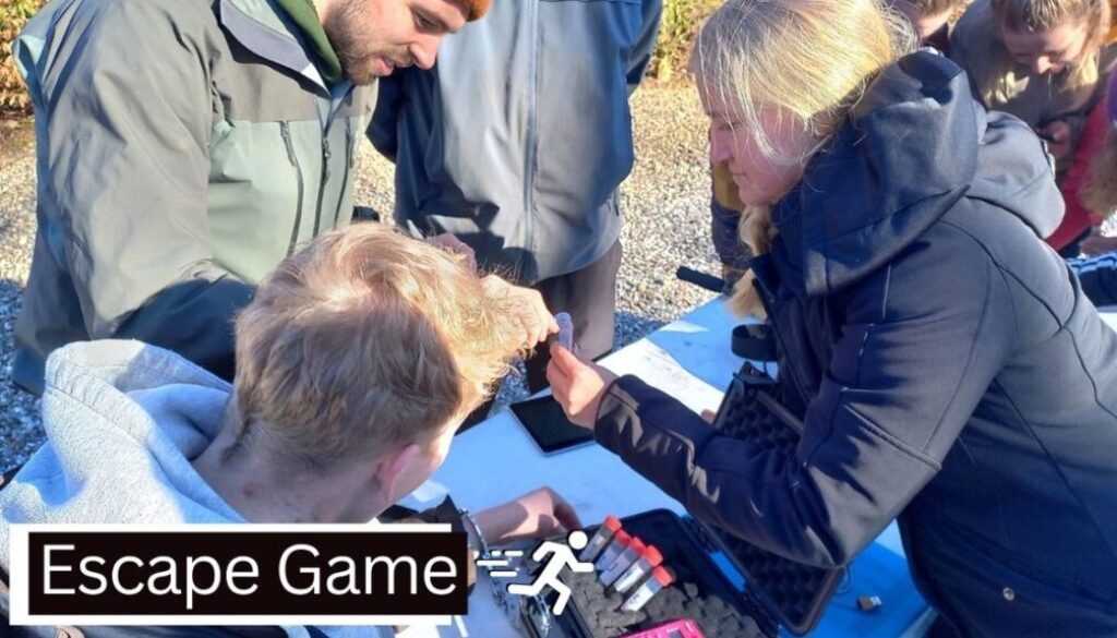 Billedet viser en gruppe engagerede deltagere i gang med en spændende udendørs Escape Game-aktivitet. De samarbejder om at løse en gåde ved hjælp af ledetråde og små redskaber, mens de er samlet omkring et bord. Stemningen er intens og fokuseret, og aktiviteten kombinerer teambuilding med sjov og udfordring i det fri.